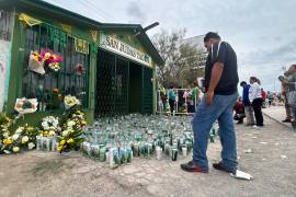 Un devoto observa las veladoras colocadas a la entrada del templo durante la jornada de celebración.