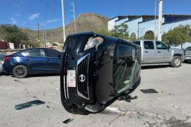 El Nissan Versa terminó sobre uno de sus costados tras impactar dos vehículos estacionados.