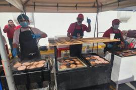 Voluntarios y veteranos de la Cruz Roja preparan las hamburguesas durante la jornada de este sábado en las instalaciones de la delegación.