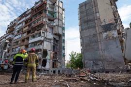 Los equipos de rescate se encuentran en el patio de un edificio de apartamentos gravemente dañado tras un ataque ruso en Kiev.