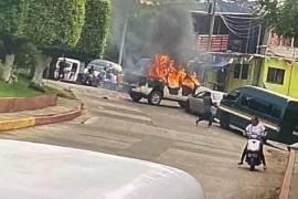 Autos incendiándose en un bloqueo por un grupo criminal en Totolapan, Morelos.