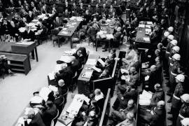 Una vista general de la sala del tribunal durante la primera sesión matutina en Nuremberg el 20 de noviembre de 1945. En primer plano, a la izquierda, se sientan los acusados con una fila de guardias detrás de ellos y su abogado sentado frente a ellos. AP/B.I. Sanders
