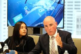 El abogado Christopher Parente habla con los medios mientras Marimar Martínez, una mujer que recibió un disparo de un agente de la Patrulla Fronteriza, lo escucha en una conferencia de prensa en Chicago.