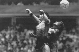 Diego Maradona, izquierda, supera en el salto al portero inglés Peter Shilton y anota el primero de sus dos goles en un partido de cuartos de final de la Copa del Mundo en Ciudad de México, 22 de junio de 1986.