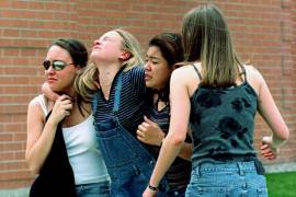 Mujeres jóvenes se dirigen a una biblioteca cerca de la escuela secundaria Columbine, donde los estudiantes y miembros de la facultad fueron evacuados después de que dos hombres armados iniciaron un tiroteo.