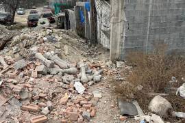 Restos de ladrillos y materiales de construcción bloquean el paso en una de las calles de la colonia Independencia.