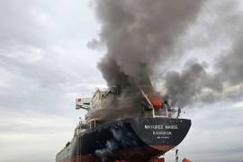 Humo emerge del Mayuree Naree, un buque granelero con bandera de Tailandia, tras ser impactado por un proyectil en el estrecho de Ormuz, al norte de Omán, el 11 de marzo de 2026.