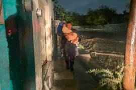 Elementos de auxilio trabajan en calles anegadas tras las lluvias registradas en la ciudad.