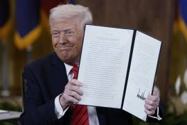 El presidente estadounidense Donald Trump sostiene una orden ejecutiva en la Sala Este de la Casa Blanca, en Washington, el jueves 20 de marzo de 2025. FOTO: