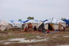 Personas sentadas cerca de sus tiendas de campaña en un campamento para personas desplazadas en Al-Huri, ciudad de Gedaref, al este de Sudán.