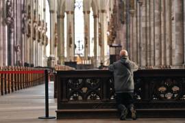 Una persona reza en la Catedral de Colonia, Alemania.