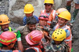 En esta imagen, distribuida por el ejército de Nepal, soldados rescatan con vida a un trabajador atrapado en un túnel durante una operación en el proyecto hidroeléctrico Trishuli-3A en el distrito de Rasuwa, en Nepal.