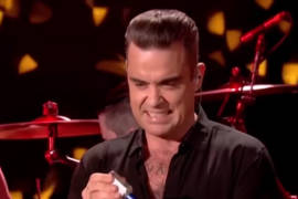 Robbie Williams desinfecta sus manos tras tocar a fans