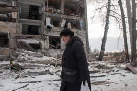 Una mujer pasa frente a un edificio dañado por los bombardeos rusos, el domingo 13 de marzo de 2022, en Járkiv, Ucrania.AP/Andrew Marienko