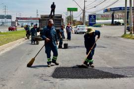 Una cuadrilla de trabajadores municipales repara baches en una vialidad de Saltillo, como parte del programa implementado por el alcalde Fraustro Siller.