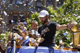 Stephen Curry saluda a los fanáticos de Warriors, mientras recorre las calles de San Francisco en el desfile de celebración del campeonato de la NBA.