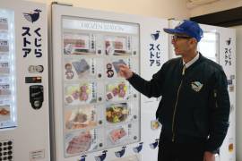 Konomu Kubo, un vocero de Kyodo Senpaku Co., explica la venta de carne de ballena en una máquina expendedora en la tienda de la empresa en Yokohama, Japón.