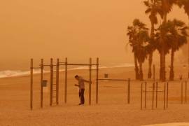 Una persona hace deporte en la playa de Aguadulce, Roquetas de Mar en Almería, bajo la intensa calima debido al polvo procedente del desierto del Sahara.