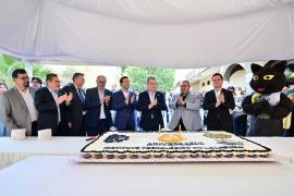 Directivos, invitados especiales y la mascota oficial de la institución compartieron el pastel del 61 aniversario.