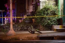 Una bicicleta perteneciente a una de las víctimas, un niño que sobrevivió a los disparos en la pierna, yace en la escena de un tiroteo en Kingsessing, Pensilvania.