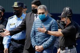 El momento en que el expresidente hondureño Juan Orlando Hernándezfue trasladado a una aeronave para ser extraditado a Estados Unidos, en una base de la Fuerza Aérea en Tegucigalpa, Honduras, el 21 de abril de 2022. FOTO: AP / ELMER MARTÍNEZ