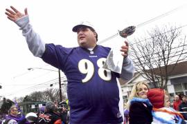 Tony Siragusa, tackle defensivo de los campeones del Super Bowl Ravens de Baltimore, alza el trofeo Vince Lombardi durante un desfile de celebración en Kenilworth, Nueva Jersey.