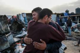 Dos palestinos se abrazan tras el mortal ataque del domingo por la noche en Rafah.