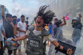 Un manifestante que viste un chaleco antibalas y lleva un escudo arrebatado a un policía grita consignas en el Singha Durbar durante las protestas.