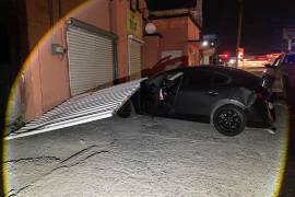 El fuerte impacto provocó que uno de los vehículos Mazda fuera proyectado contra el portón de un negocio, el cual quedó completamente derribado tras el accidente registrado durante la madrugada.