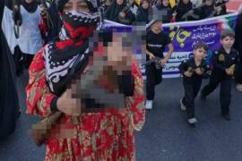 Una mujer marcha junto a otras mujeres y niños como parte de la nueva campaña de reclutamiento de Irán basada en el ‘autosacrificio’.
