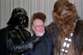 Star Wars characters, Darth Vader, left, and Chewbacca, right, pose with Boston Pops Orchestra Conductor John Williams, backstage after Williams conducted the Pops in music from the movies he orchestrated, Saturday night, July 12, 1997, at Tanglewood in Lenox, Mass. The audience in The Shed viewed the movie excerpts on a large screen, while those on the lawn watched two oversized screens as the orchestra played. (AP Photo/Alan Solomon)