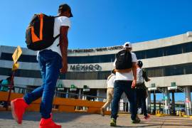 Solicitantes de asilo que fueron regresados por las autoridades de Estados Unidos en virtud del programa Permanecer en México son escoltados por un agente de migración mexicano rumbo a Nuevo Laredo, México.