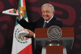 Andrés Manuel López Obrador, presidente de México, muestra un par de tenis que artesanos de Tlaxcala le fabricaron.