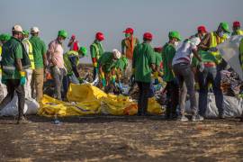 Trabajadores recogen escombros el 12 de marzo de 2019 en el lugar donde un Boeing 737 Max 8 de Ethiopian Airlines se estrelló poco después del despegue, matando a las 157 personas a bordo.