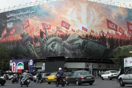 Unos iraníes pasan junto a una valla publicitaria antiestadounidense en Teherán, Irán el 9 de septiembre de 2026.
