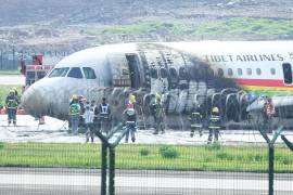 Los bomberos revisan un avión de Tibet Airlines después de incendiarse durante el despegue en el Aeropuerto Internacional de Chongqing Jiangbei en Chongqing, China.