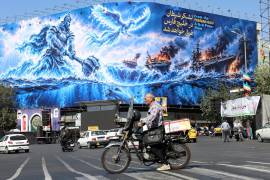 Un iraní conduce junto a una valla publicitaria antiamericana con una frase en persa que dice: “El ejército del diablo se ahogará en el golfo Pérsico”, en la plaza Enghelab de Teherán, Irán, el 21 de septiembre de 2026.