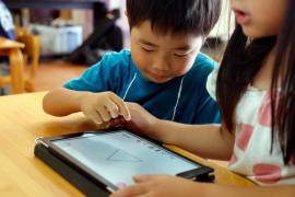 Niños usan dispositivos digitales en una escuela en Yoshikawa, un suburbio de Tokio, el 12 de julio del 2018.