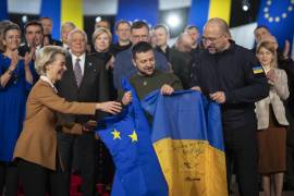 El presidente de Ucrania, Volodymyr Zelensky, la presidenta de la Comisión Europea, Ursula von der Leyen y al primer ministro de Ucrania, Denys Shmyhal (C-R), sosteniendo las banderas de la UE y Ucrania en Kiev.