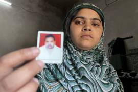 Nisha Qureshi, hija del comerciante musulmán Qasim Qureshi, que murió en un linchamiento en la India motivado por mensajes falsos y odio religioso, sostiene una foto de su padre el pasado 22 de abril en Harpur.