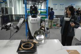 Una trabajadora controla a distancia a robots humanoides durante los preparativos para la Feria Internacional China de Comercio en Servicios (CIFTIS) en un centro de entrenamiento de robots en Beijing, China.