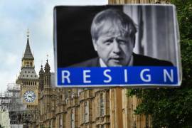 Un manifestante sujeta un cartel pidiendo la dimisión del primer ministro, Boris Johnson, frente al Parlamento en Londres.