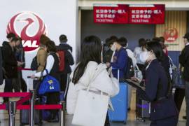 Una trabajadora de la aerolínea Japan Airlines ayuda a viajeros en el Aeropuerto Internacional de Osaka, a las afueras de Osaka, Japón, el 26 de diciembre de 2024, luego de que la compañía anunció que había sufrido un ciberataque.