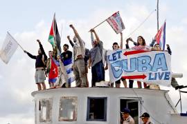 Integrantes del Convoy Nuestra América saludan a su llegada con ayuda humanitaria al puerto en La Habana.