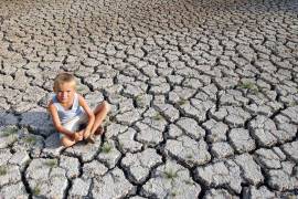 Un niño descansa sobre un cauce de agua seco en la región francesa de la Dordoña.