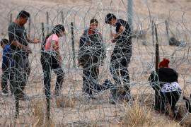 Migrantes intentan cruzar la cerca de alambres en la frontera que divide a México de los Estados Unidos, el 8 de febrero de 2024, en Ciudad Juárez, México.