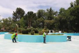 Personal municipal aplica pintura en el Lago República de la Alameda Zaragoza como parte de trabajos de rehabilitación del espacio.