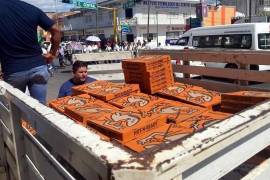 Habían llegado tres camionetas cargadas con cientos de pizzas.