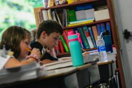 Isaiah Felion, estudiante de quinto grado de la escuela primaria NewBrook en Newfane, Vermont, toma notas el primer día de clases.