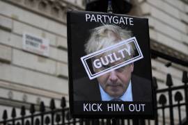 Un manifestante sostiene una pancarta del primer ministro británico, Boris Johnson, en las afueras de Downing Street en Londres, Gran Bretaña.
